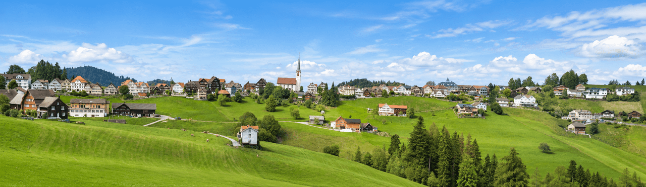 och über dem Appenzellerland liegt Schwellbrunn auf rund 972 Metern über Meer. Das schmucke Dorf begeistert mit seinen traditionellen Häusern, dem historischen Ortsbild und einer Aussicht, die über die sanften Hügel bis zum Alpstein und Bodensee reicht.